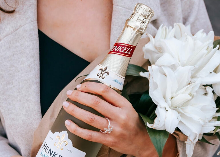 Handmodel Eva Schug mit einer Flasche Sekt in der Hand